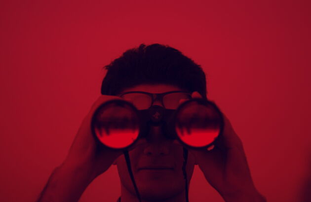 Ein Mann schaut durch ein Fernglas.