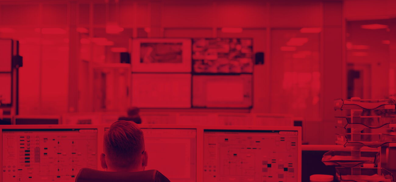 Rötliches Bild - Ein Mann sitzt an einem Computer.